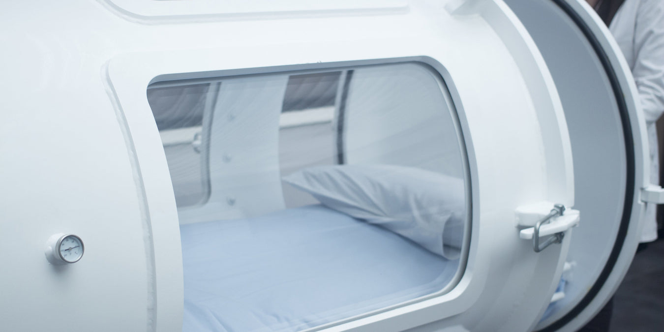 Hypobaric oxygen chamber with a person inside, likely undergoing hyperbaric oxygen therapy.